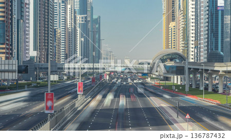 Busy Sheikh Zayed Road timelapse, metro railway and modern skyscrapers around in luxury Dubai city 136787432