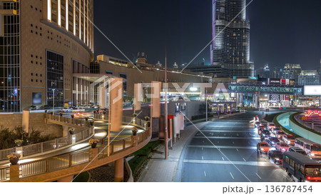 Car traffic on road near mall at night in downtown timelapse. 136787454