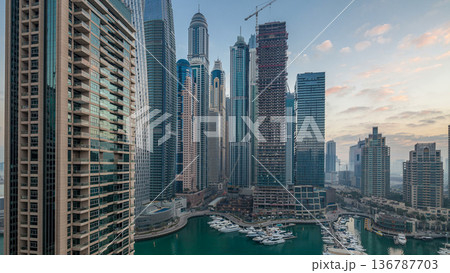 Aerial view of modern skyscrapers night to day timelapse before sunrise in Dubai Marina in Dubai, UAE. Aerial view of modern skyscrapers night to day timelapse before sunrise in Dubai Marina in Dubai, UAE. 136787703