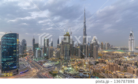 Dubai Downtown day to night timelapse. Aerial view over big futuristic city by night. Dubai Downtown day to night timelapse. Aerial view over big futuristic city by night. 136787898