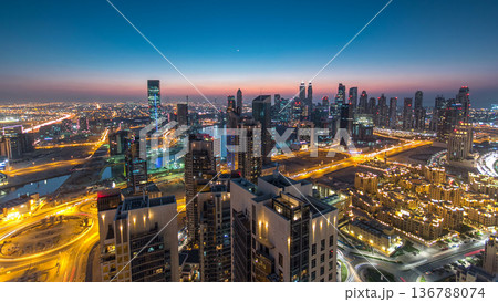 Aerial view of a big modern city day to night timelapse. Business bay, Dubai, United Arab Emirates. Aerial view of a big modern city day to night timelapse. Business bay, Dubai, United Arab Emirates. 136788074