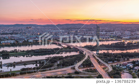 Aerial panoramic view over Vienna city with skyscrapers, historic buildings and a riverside promenade day to night timelapse in Austria. 136788239