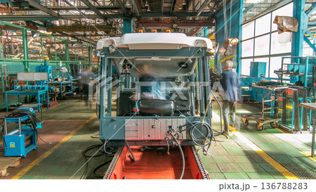 Conveyor assembly stage the body of tractor at big industrial factory timelapse Conveyor assembly stage the body of tractor at big industrial factory timelapse 136788283