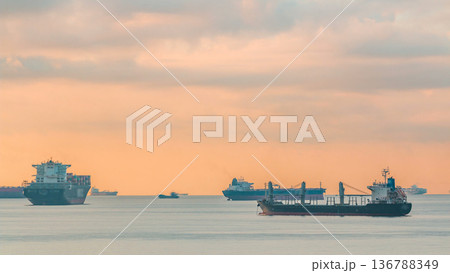 Early morning scene of cargo ships and tankers anchored off of Singapore's coast timelapse 136788349
