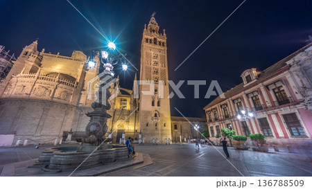 La Giralda and Seville Cathedral timelapse hyperlapse glowing under the night sky. 136788509