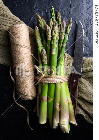 Bundled green asparagus tied with twine and knife Bundled green asparagus tied with twine and knife 136788774