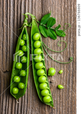 Fresh green peas in pods on wooden surface in top view 136788809