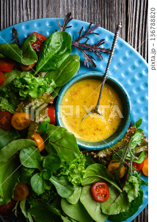 Fresh salad greens with honey mustard dressing in bowl 136788820