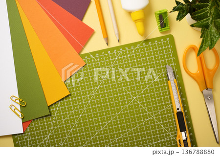 Workspace for hobby with cutting mat, scissors, knife, pencil, eraser, tape and paper sheets. Copy space Workspace for hobby with cutting mat, scissors, knife, pencil, eraser, tape and paper sheets. Copy space 136788880