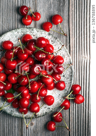 Top view of ripe cherries scattered on wooden background Top view of ripe cherries scattered on wooden background 136788895