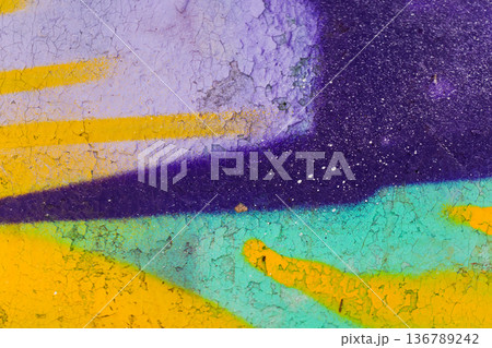 Colorful graffiti elements on a weathered wall with bold purple, teal, and yellow lines Colorful graffiti elements on a weathered wall with bold purple, teal, and yellow lines 136789242