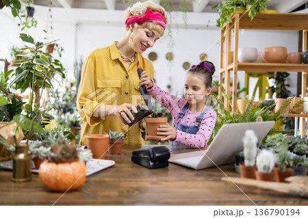 A young girl and her mother enjoy a fun afternoon of gardening, learning about plants and nature 136790194