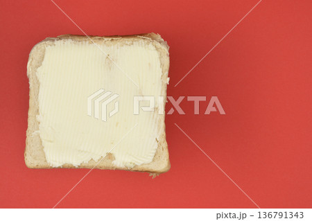 Butter Spread on Bread over Red Background Butter Spread on Bread over Red Background 136791343