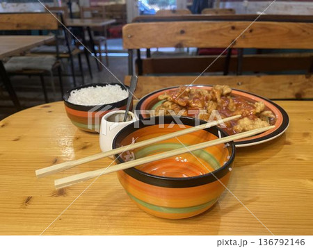 a bowl of food and kitchen's plate on a table a bowl of food and kitchen's plate on a table 136792146