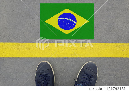 Start on an asphalt road with the Brazilian flag and legs in shoes. Business, Immigration and Travel Start on an asphalt road with the Brazilian flag and legs in shoes. Business, Immigration and Travel 136792181