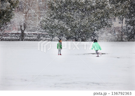 雪の降る公園で楽しそうにはしゃぎ回る子供達 136792363