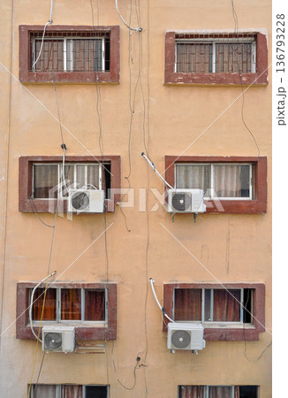 Air conditioning external units with large fans on old building facade wall near windows, many untidy cables near Air conditioning external units with large fans on old building facade wall near windows, many untidy cables near 136793228