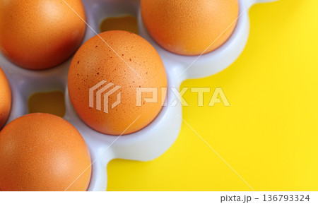 Beige coloured eggs on yellow board, closeup detail, space for text right down corner 136793324