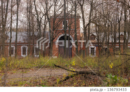 Forgotten brick building emerges from the autumn woods at dusk, whispering stories of the past and nature's reclaim Forgotten brick building emerges from the autumn woods at dusk, whispering stories of the past and nature's reclaim 136793433