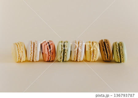 Tasty french macarons on a peach pastel background. Tasty french macarons on a peach pastel background. 136793787
