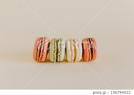 Tasty french macarons on a peach pastel background. Tasty french macarons on a peach pastel background. 136794022