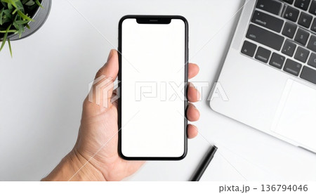 手に持ったスマートフォンのモックアップ 136794046