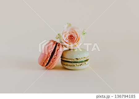 Tasty french macarons with tender rose flowers on a peach pastel background. 136794185