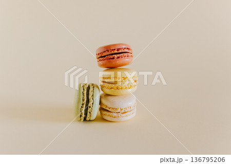 Tasty french macarons on a peach pastel background. Tasty french macarons on a peach pastel background. 136795206