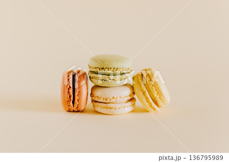 Tasty french macarons on a peach pastel background. Tasty french macarons on a peach pastel background. 136795989