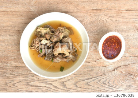 boiled braised beef meat and tendon in herb brown soup on plate dipping spicy chili sauce boiled braised beef meat and tendon in herb brown soup on plate dipping spicy chili sauce 136796039