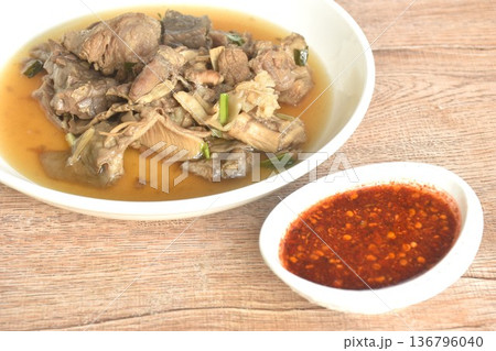 boiled braised beef meat and tendon in herb brown soup on plate dipping spicy chili sauce boiled braised beef meat and tendon in herb brown soup on plate dipping spicy chili sauce 136796040