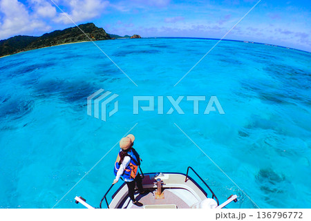 ボートの先端から透き通るターコイズブルーの海を眺める女性と南国の風景 ボートの先端から透き通るターコイズブルーの海を眺める女性と南国の風景 136796772