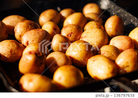 Golden roasted potatoes cooking in a warm kitchen on a cozy autumn evening Golden roasted potatoes cooking in a warm kitchen on a cozy autumn evening 136797638