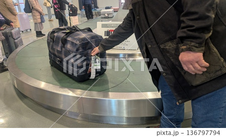 空港の手荷物受取所 バゲージクレームで荷物を受け取る 空港の手荷物受取所 バゲージクレームで荷物を受け取る 136797794
