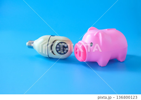 Security camera cctv and piggy bank on color background. Security camera cctv and piggy bank on color background. 136800123