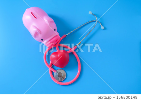 piggy bank with stethoscope and red heart on color background. 136800149