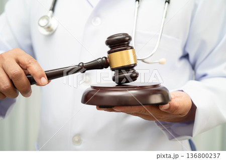 Asian doctor holding court hammer for and crime law justice, forensic medicine. 136800237