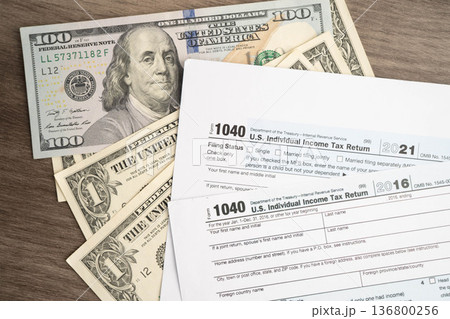Tax form 1040 U.S. Individual Income Tax Return with dollar banknotes money. Tax form 1040 U.S. Individual Income Tax Return with dollar banknotes money. 136800256