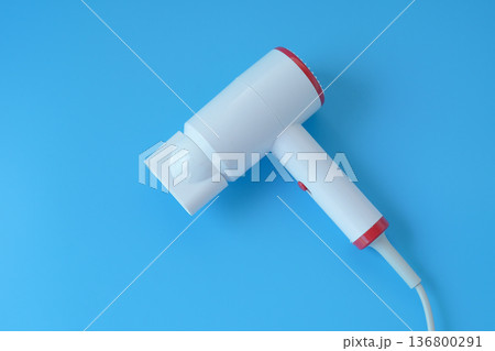 Fashionable hair dryer for hairdressing on blue background. Fashionable hair dryer for hairdressing on blue background. 136800291