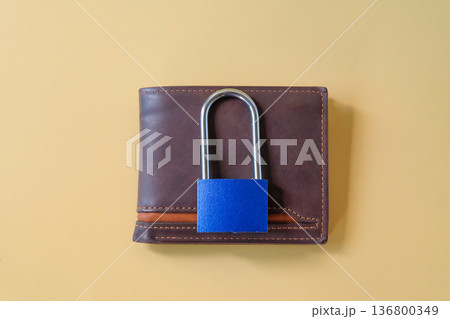 Padlock on leather wallet with paper bills. 136800349