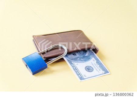 Padlock on leather wallet with paper bills. 136800362