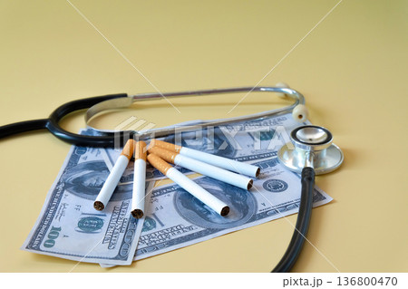 A cigarettes and stethoscope over bank note,Health concept. 136800470