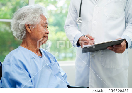 Doctor taking care, help and encourage Asian elder senior woman patient in clinic hospital. Doctor taking care, help and encourage Asian elder senior woman patient in clinic hospital. 136800881