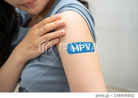 HPV, Human papillomavirus, Asian young woman receiving vaccine with blue bandage. 136800882