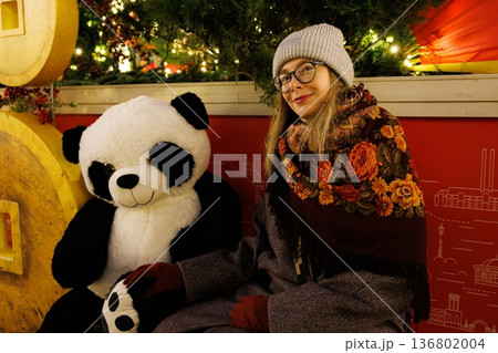 Enjoying a cozy evening with a giant panda in a festive winter setting Enjoying a cozy evening with a giant panda in a festive winter setting 136802004