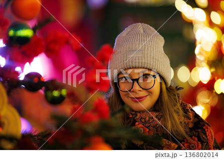 Joyful celebration of winter spirit in a festive market with colorful lights and cheerful gatherings 136802014