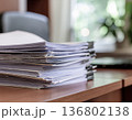 机の上に積み重なった大量の書類｜事務作業とペーパーワークのイメージ 136802138