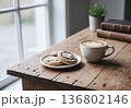木製テーブルに置かれたカフェラテとクッキー｜窓辺のおうちカフェタイム 136802146