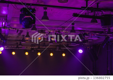 Dramatic purple stage lighting illuminates overhead rigging and spotlights Dramatic purple stage lighting illuminates overhead rigging and spotlights 136802755