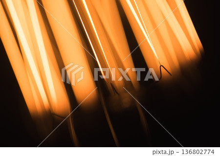 An abstract macro shot of an incandescent bulb shows a vivid orange filament glow An abstract macro shot of an incandescent bulb shows a vivid orange filament glow 136802774